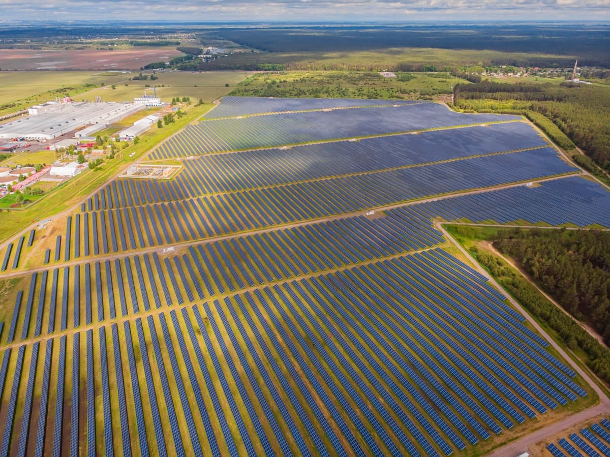 Vista aérea de uma usina solar em operação, com longas fileiras de módulos fotovoltaicos