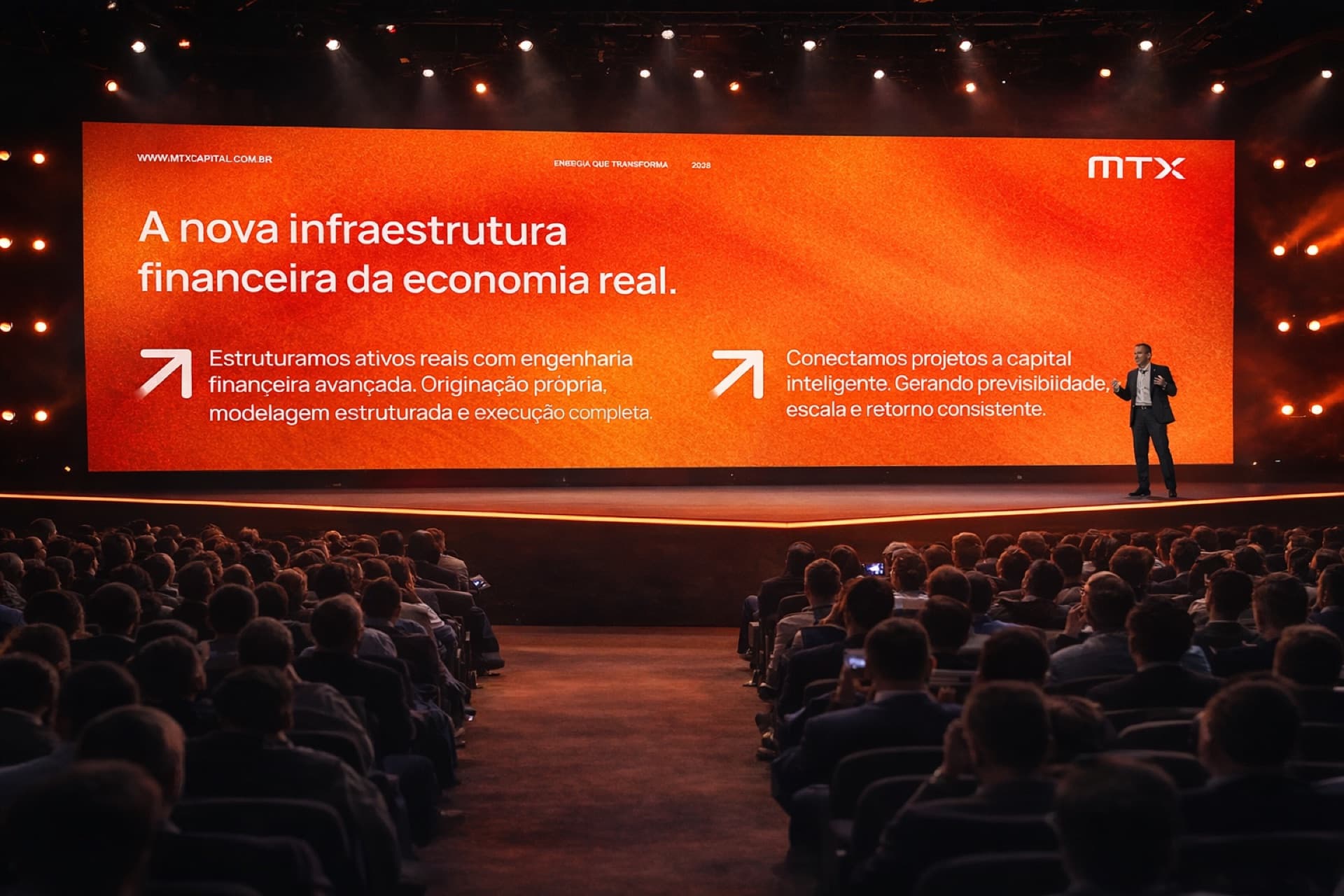 Encontro da MTX em auditório, com plateia de investidores diante do palco